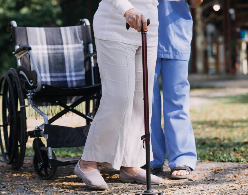 Senior getting off the wheelchair with help of cane