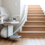 Custom curved stairlift with a comfortable beige seat installed along a residential wooden staircase to improve home mobility and accessibility.
