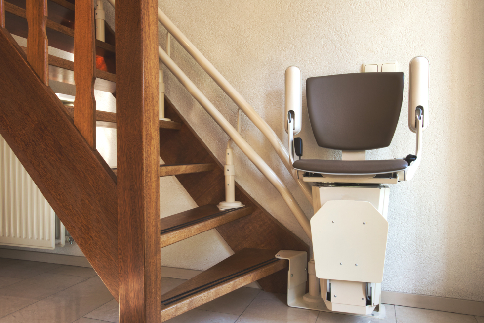 Residential custom stairlift chair mounted on an open-riser wooden staircase for safe multi-floor accessibility